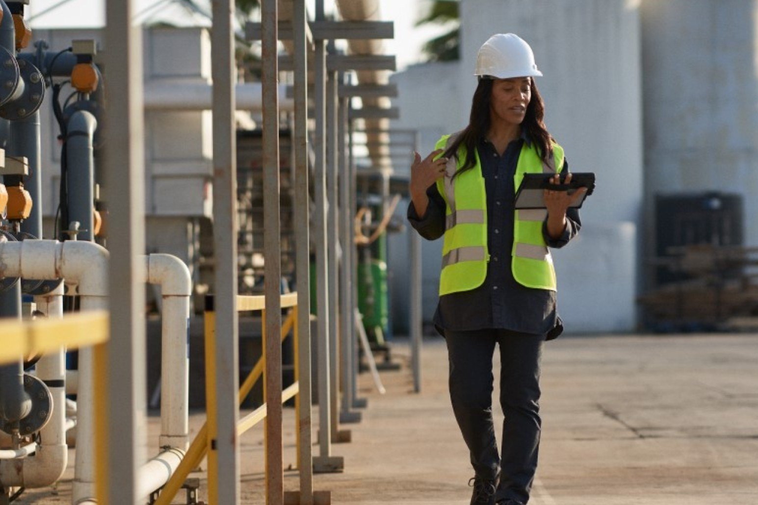 Worker checking a tablet on a production site
